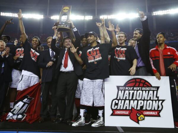 Louisville Cardinals head coach Pitino holds up the trophy as he and his team celebrate after defeating the Michigan Wolverines in their NCAA men's Final Four championship basketball game in Atlanta